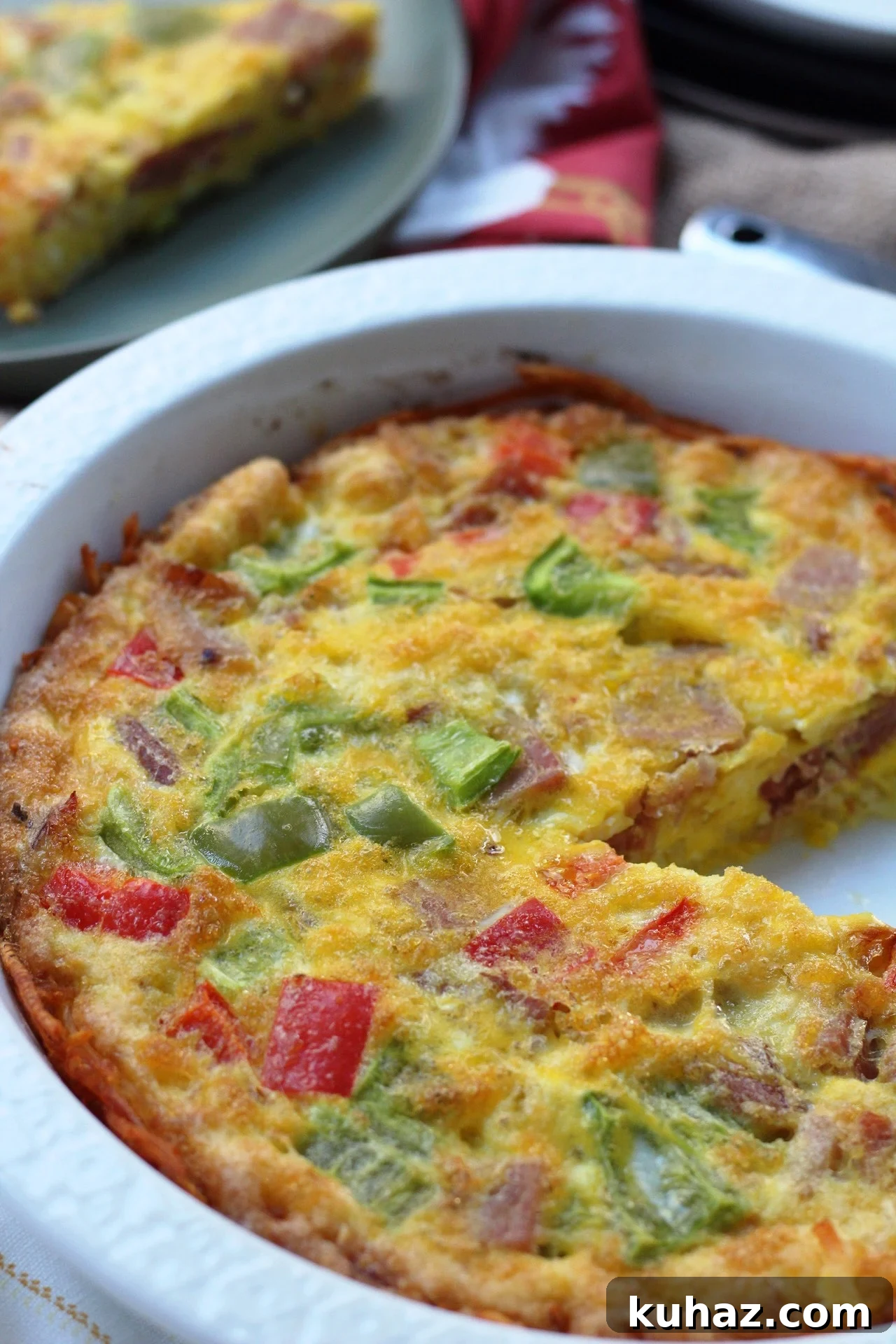 Whole30 ham egg bake with eggs, vegetables, cooked ham, and a hash brown crust.