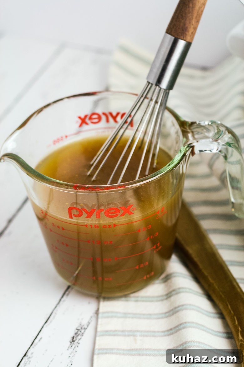 Slow Cooker Pork Tenderloin with Savory Gravy 5 Measuring Cup With Gravy Mixture being whisked