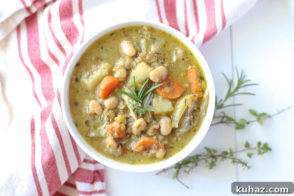 One Pot Chicken and Lentil Soup for Weeknights 3 Bowl of chicken lentil soup with carrots, potatoes, and beans.