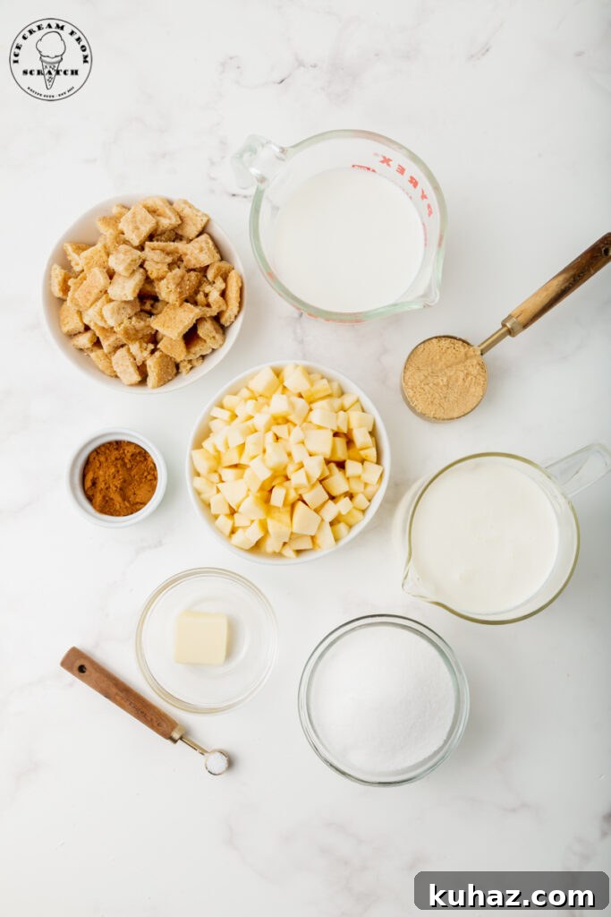Ingredients for apple ice cream, each in separate bowls on a marble countertop. Including cookies, apples, cinnamon, and dairy items.