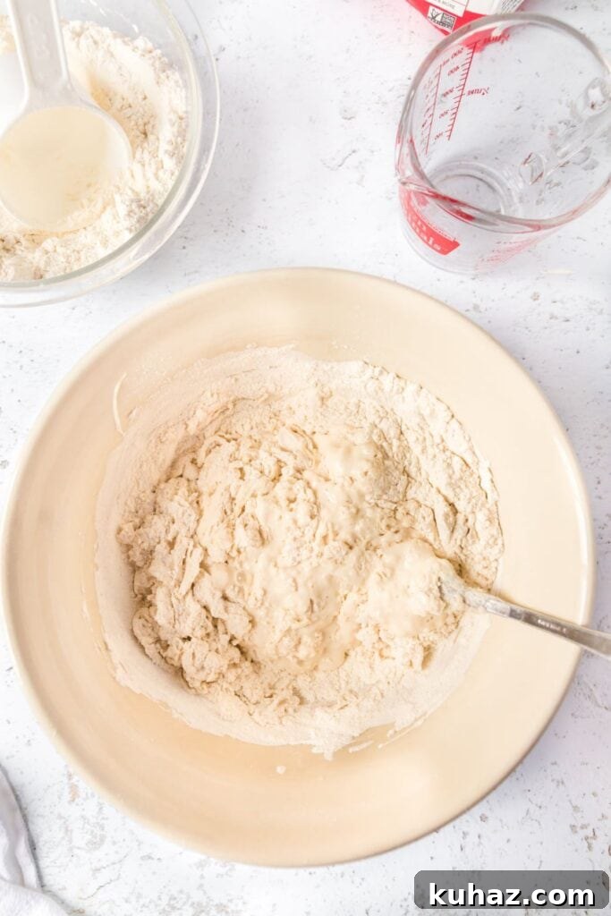 Sourdough ingredients in a beige mixing bowl getting stirred up.
