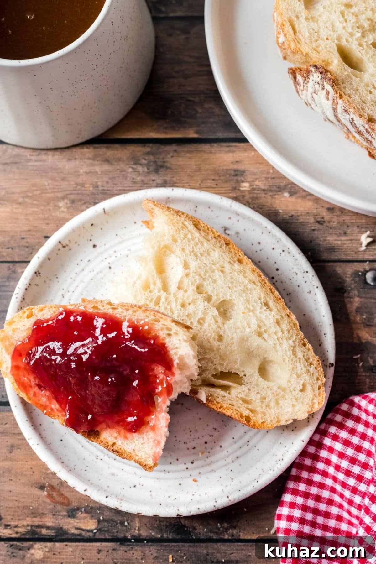 Sliced sourdough bread sliced with strawberry jam spread on it.