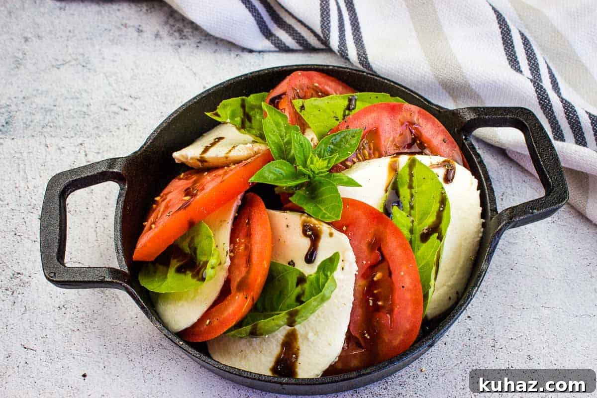 17 Authentic Italian Dinner Recipes Even Nonna Will Love 15 A top-down shot of a classic caprese salad in a black dish.
