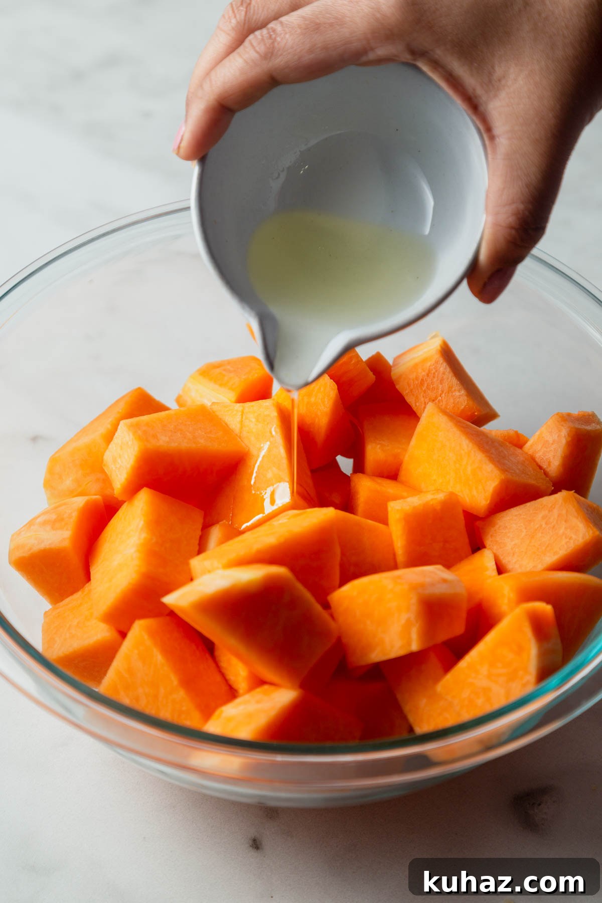 adding oil to the pumpkin cubes.