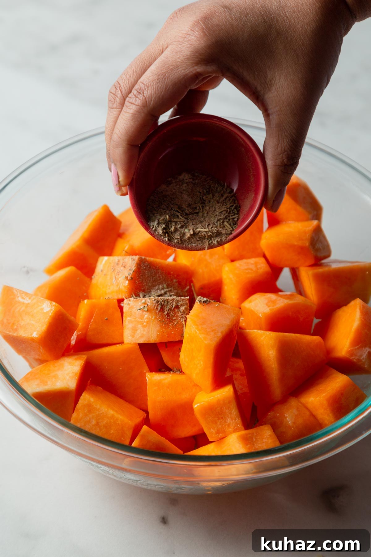 adding spices to the pumpkin cubes.