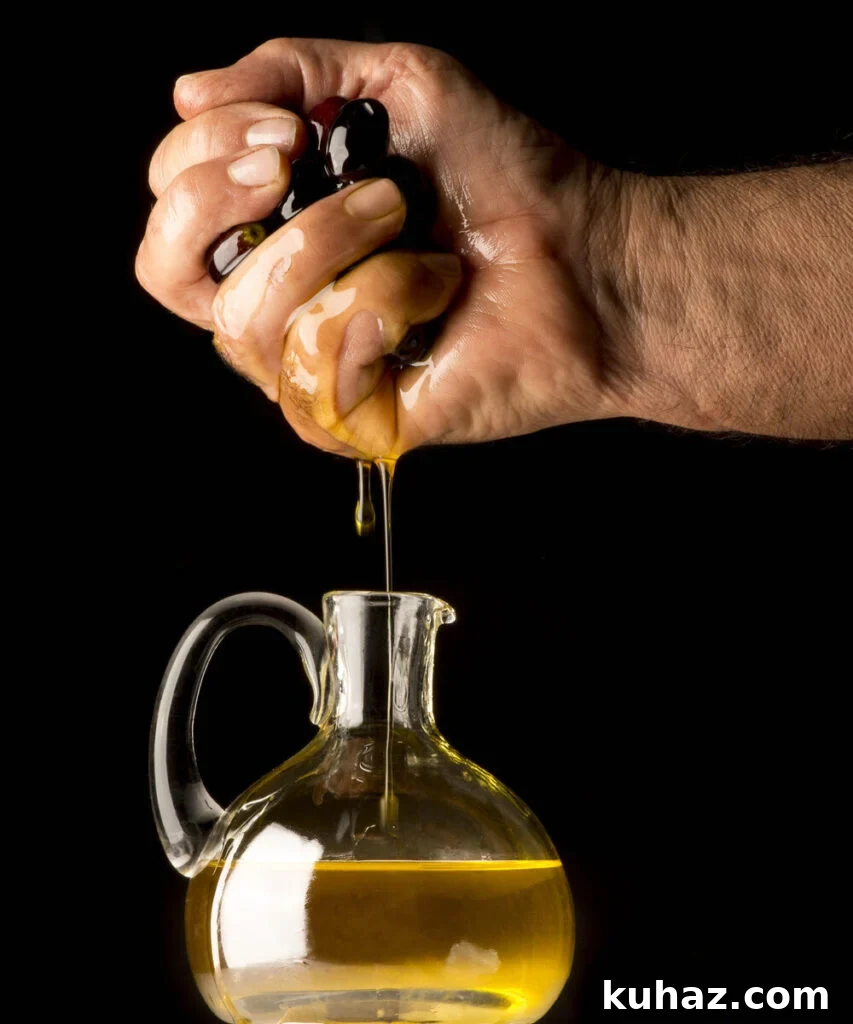 Hand squeezing oil from olives