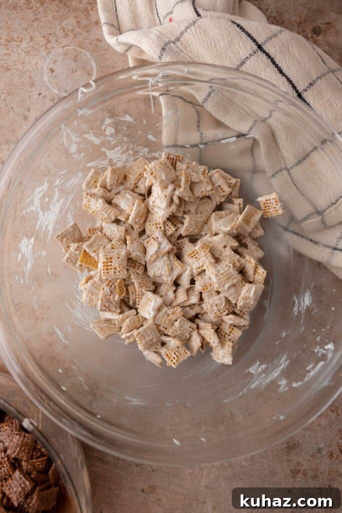 No-Bake Cookies and Cream Muddy Buddies Recipe 7 white chocolate chips getting mixed with chex cereal