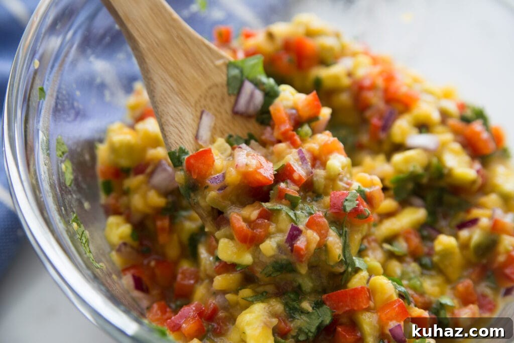 Instant Pot Chicken Carnitas with Avocado Peach Salsa Recipe 4 A bowl of avocado peach salsa being scooped up with a wooden spoon