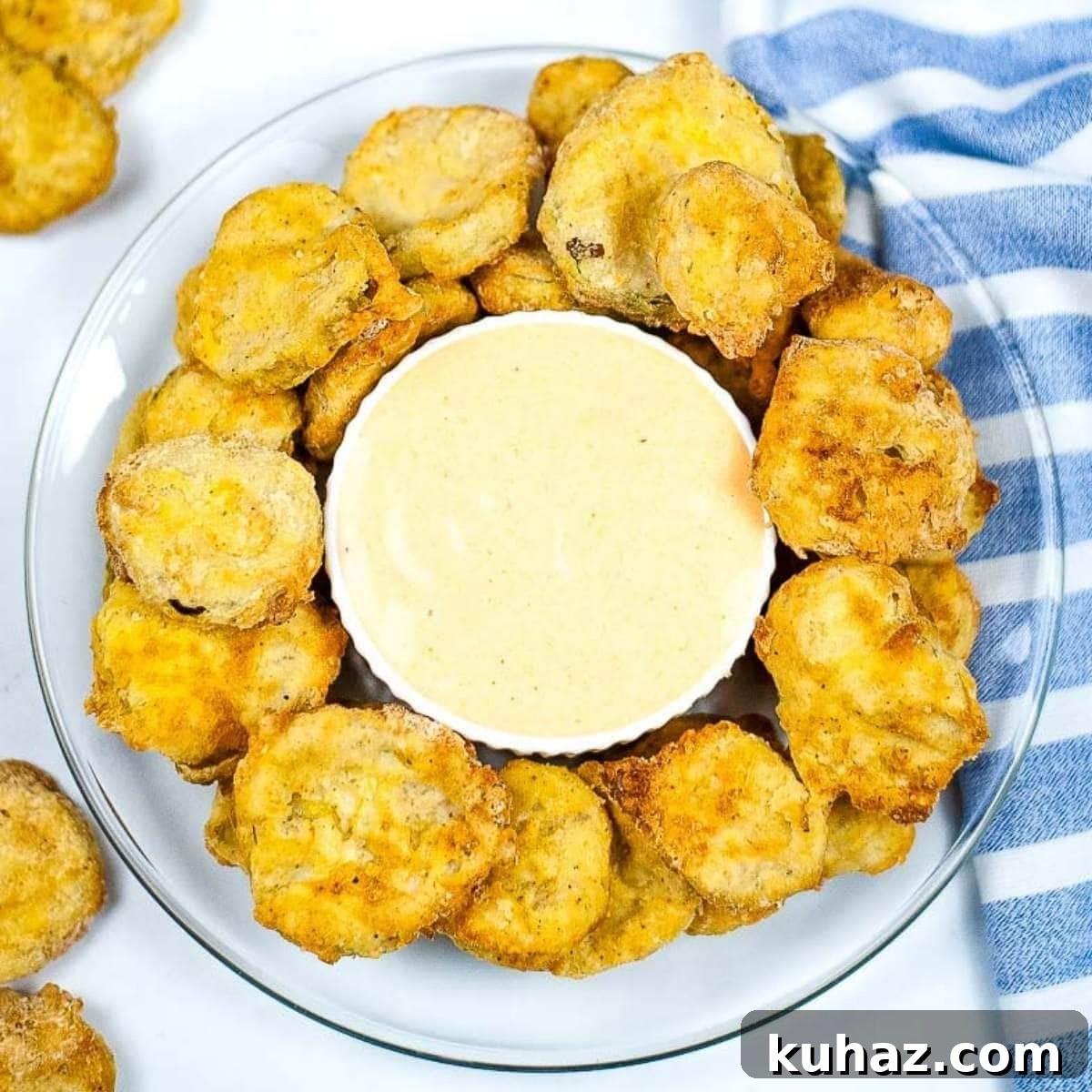 Crispy Air Fryer Pickle Chips Recipe 2 Top view of fried pickles on glass plate with sauce fresh out of the air fryer.