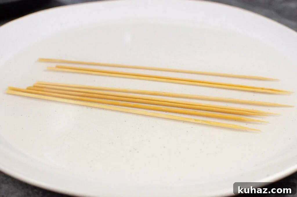 How to Make Authentic Tandoori Chicken Tikka Kebabs 8 Wooden kebab sticks soaking in water on a white dish