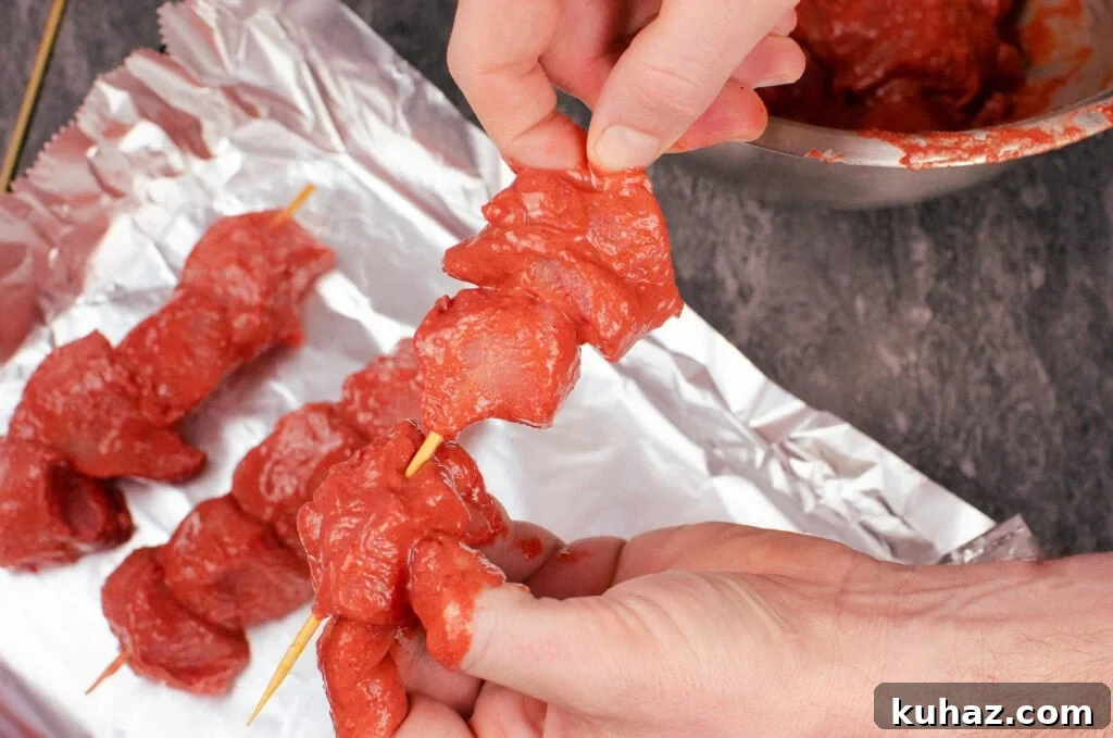 How to Make Authentic Tandoori Chicken Tikka Kebabs 9 Placing the marinated chicken cubes on to kebob sticks by hand