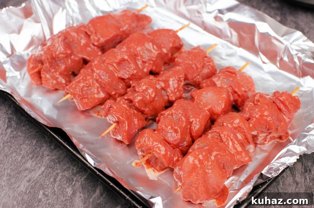 How to Make Authentic Tandoori Chicken Tikka Kebabs 11 Chicken Tikka Kebabs on a baking tray lined with silver tin foil